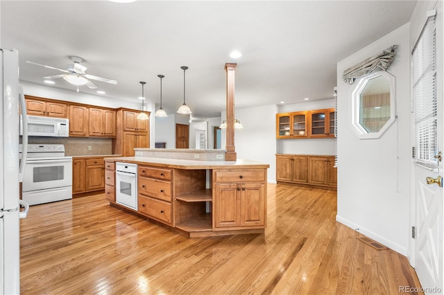 kitchen featuring white appliances, tasteful backsplash, hanging light fixtures, ceiling fan, and light wood-type flooring