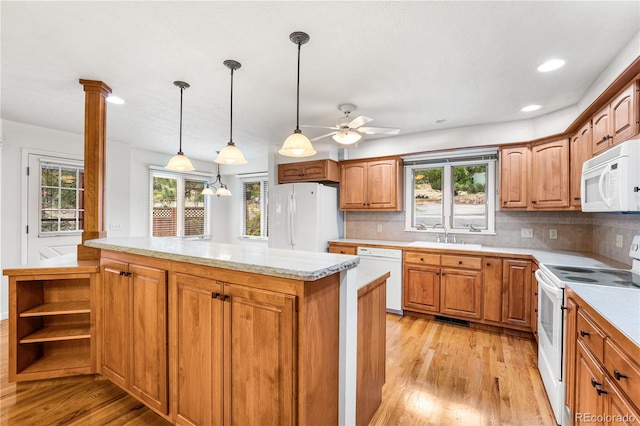 kitchen featuring white appliances, a wealth of natural light, tasteful backsplash, and light hardwood / wood-style floors