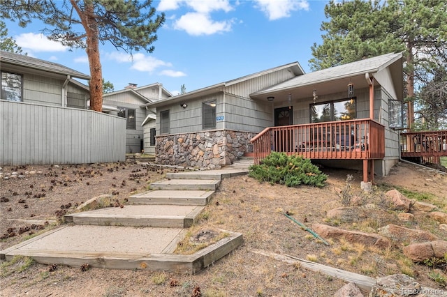 rear view of property featuring a deck