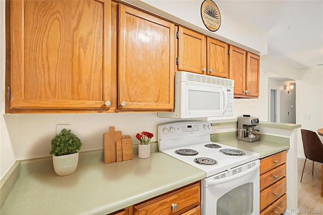 10150 E Virginia Ave Unit 7-302, Denver, CO 80247 - kitchen with white appliances, light countertops, brown cabinets, and wood finished floors
