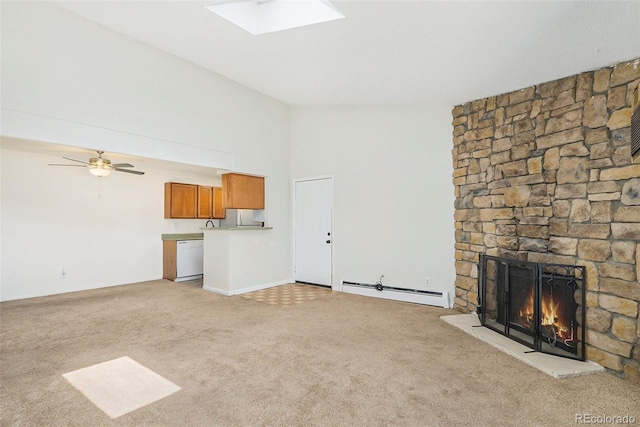 10150 E Virginia Ave Unit 7-302, Denver, CO 80247 - unfurnished living room with a baseboard radiator, light carpet, a stone fireplace, ceiling fan, and a skylight