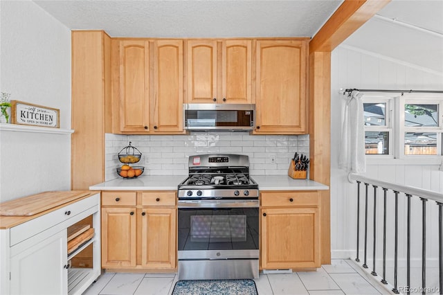 kitchen featuring a textured ceiling, appliances with stainless steel finishes, light brown cabinetry, decorative backsplash, and lofted ceiling with beams