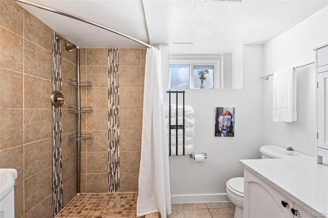 bathroom featuring toilet, tile patterned floors, walk in shower, and vanity