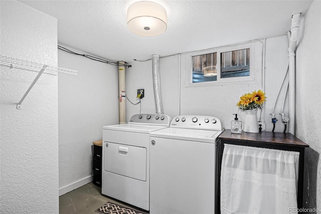 laundry area featuring washing machine and dryer and a textured ceiling