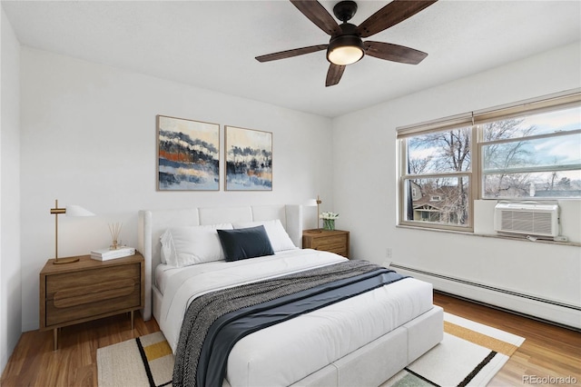 bedroom with wood-type flooring, a baseboard heating unit, cooling unit, and ceiling fan