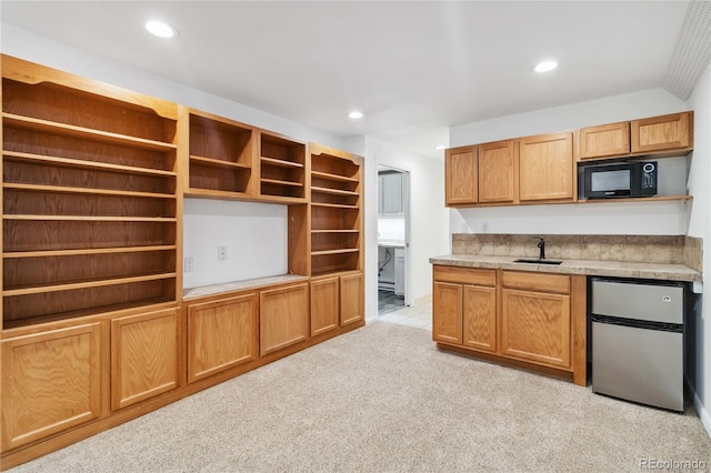 kitchen featuring stainless steel fridge, sink, and light carpet