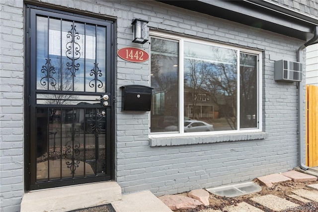 entrance to property featuring a wall unit AC