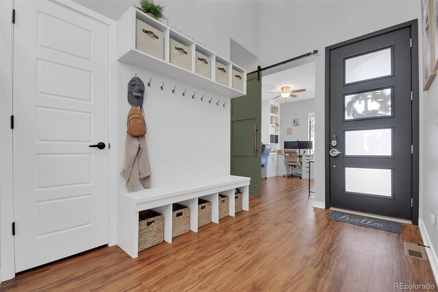 18085 E 107th Pl, Commerce City, CO 80022 - mudroom featuring wood finished floors, a barn door, and a high ceiling