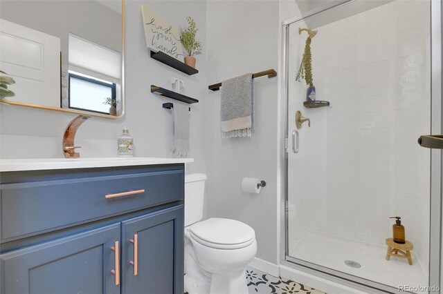 18085 E 107th Pl, Commerce City, CO 80022 - bathroom featuring toilet, a stall shower, vanity, and baseboards