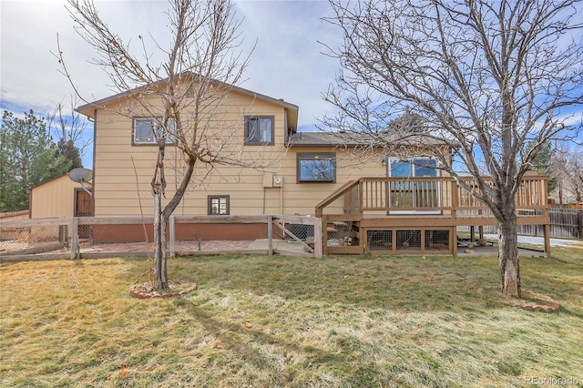 back of house with a wooden deck and a lawn