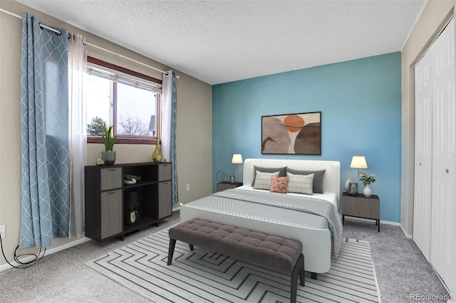 bedroom with carpet, a textured ceiling, and a closet