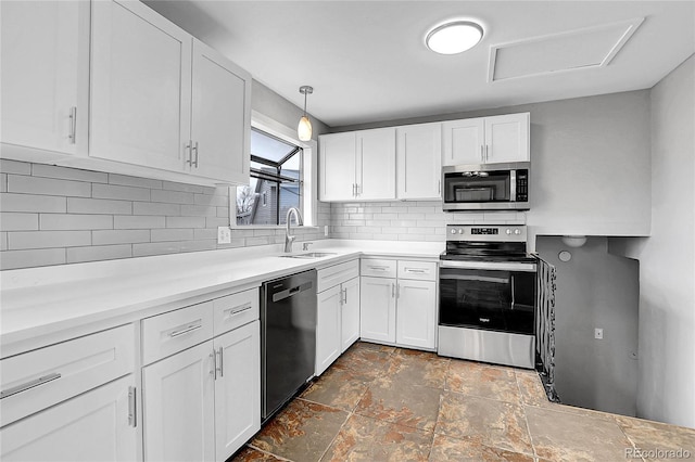 kitchen with pendant lighting, sink, white cabinets, and appliances with stainless steel finishes