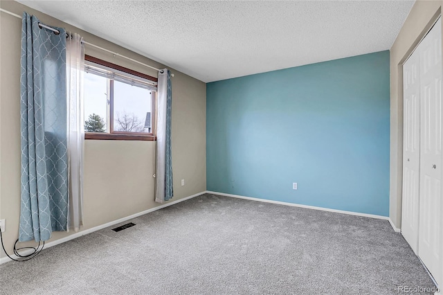 carpeted spare room featuring a textured ceiling