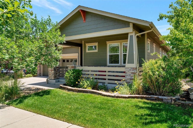 view of front of property with a porch, a garage, and a front yard