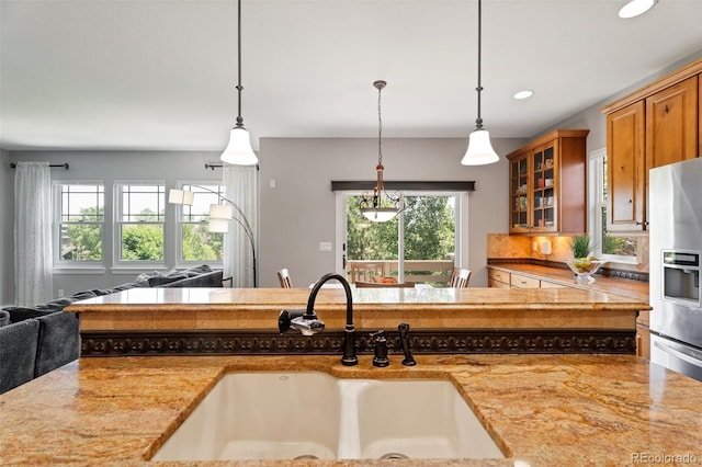 kitchen with backsplash, decorative light fixtures, stainless steel fridge with ice dispenser, and sink