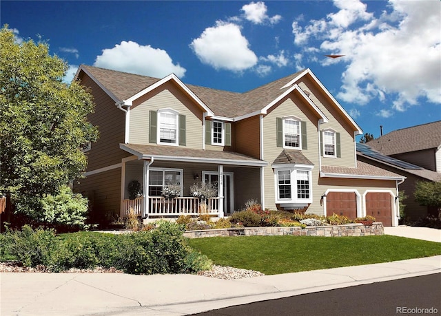 view of front of property with a garage, covered porch, and a front yard