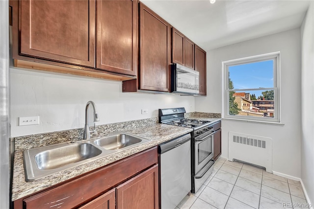 2100 N Franklin St Unit 15, Denver, CO 80205 - kitchen featuring radiator, stainless steel appliances, a sink, light tile patterned floors, and light countertops