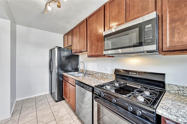 2100 N Franklin St Unit 15, Denver, CO 80205 - kitchen with stainless steel appliances, a sink, brown cabinets, light tile patterned floors, and baseboards