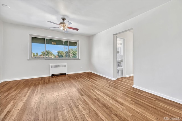 2100 N Franklin St Unit 15, Denver, CO 80205 - empty room featuring radiator heating unit, wood-type flooring, ceiling fan, and baseboards