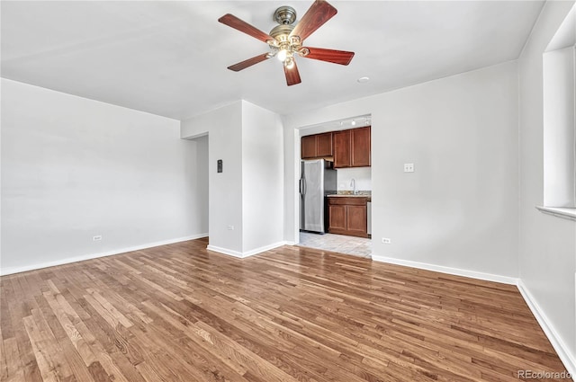 2100 N Franklin St Unit 15, Denver, CO 80205 - unfurnished living room with light wood finished floors, ceiling fan, a sink, and baseboards