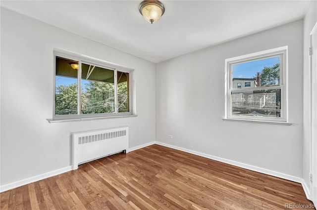2100 N Franklin St Unit 15, Denver, CO 80205 - spare room featuring radiator, baseboards, and wood finished floors