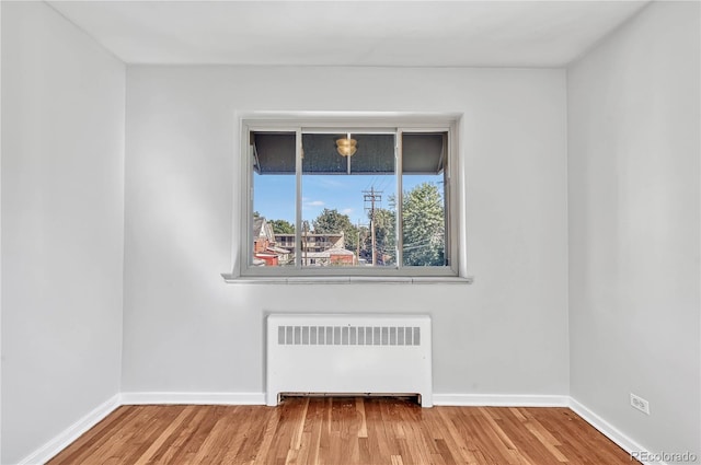2100 N Franklin St Unit 15, Denver, CO 80205 - unfurnished room featuring radiator heating unit, wood finished floors, and baseboards