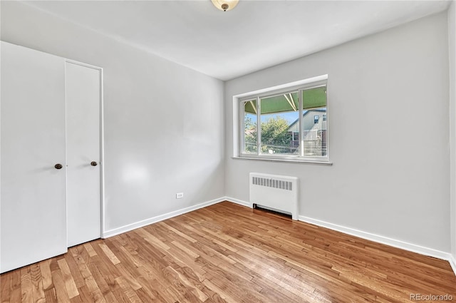 2100 N Franklin St Unit 15, Denver, CO 80205 - unfurnished room featuring radiator, wood finished floors, and baseboards