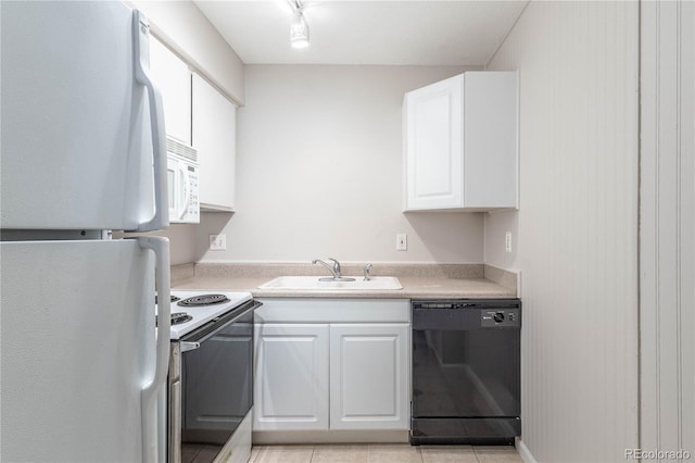 kitchen featuring white appliances, track lighting, sink, light tile patterned floors, and white cabinetry