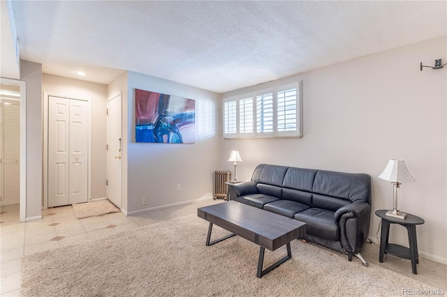 tiled living room with radiator heating unit and a textured ceiling