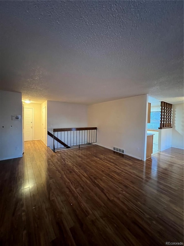 additional living space featuring hardwood / wood-style floors and a textured ceiling