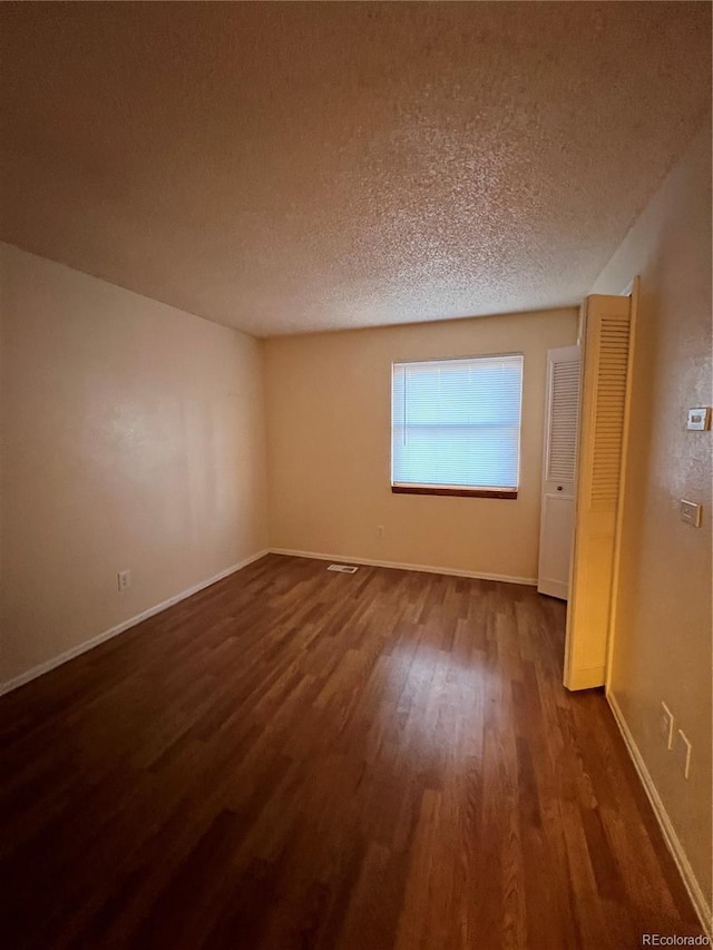 unfurnished room with a textured ceiling and hardwood / wood-style flooring