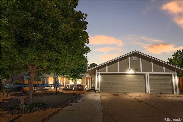 16673 E Kent Dr, Aurora, CO 80013 - view of front of home with concrete driveway, a trampoline, a garage, and stucco siding