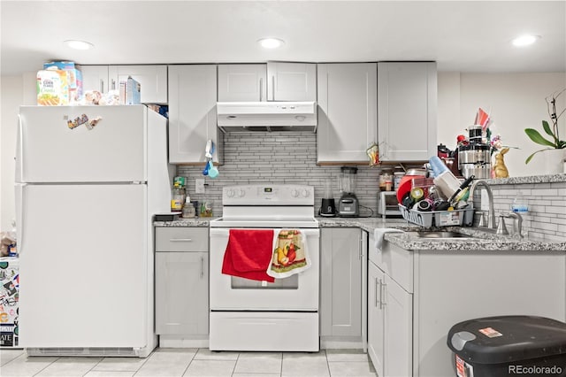 16673 E Kent Dr, Aurora, CO 80013 - kitchen featuring white appliances, under cabinet range hood, tasteful backsplash, light tile patterned floors, and recessed lighting