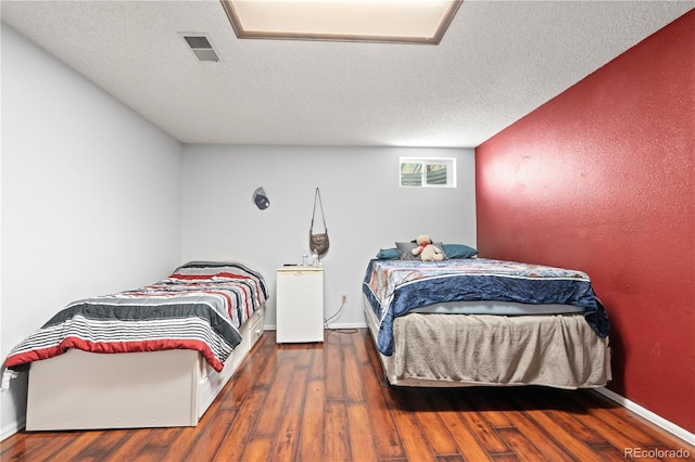 16673 E Kent Dr, Aurora, CO 80013 - bedroom with wood finished floors and a textured ceiling