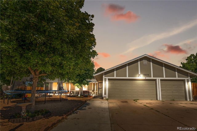 16673 E Kent Dr, Aurora, CO 80013 - view of front of home with driveway, a garage, a trampoline, and stucco siding