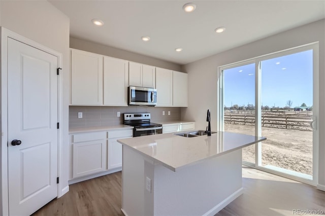 kitchen featuring appliances with stainless steel finishes, backsplash, white cabinetry, and sink