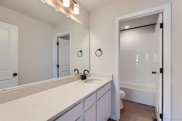 full bathroom with bathing tub / shower combination, vanity, hardwood / wood-style flooring, and toilet