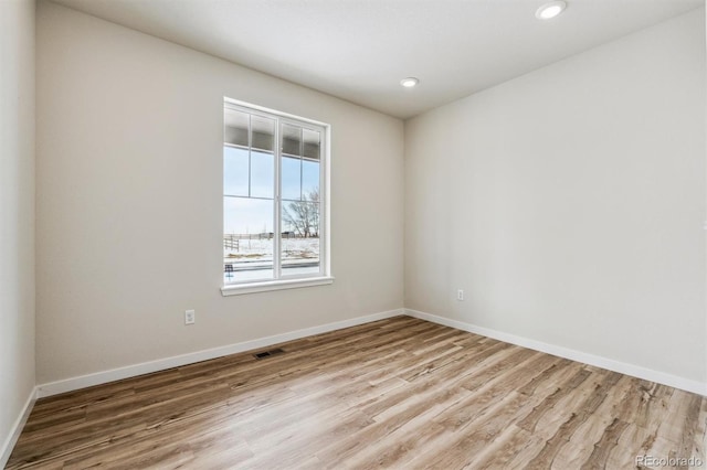 unfurnished room with baseboards, visible vents, wood finished floors, and recessed lighting