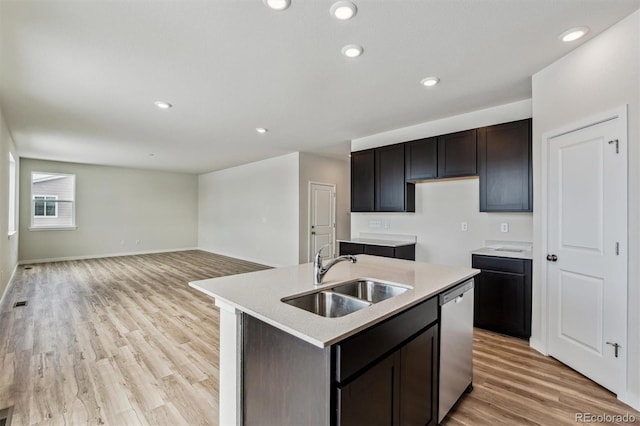 kitchen featuring light wood-style flooring, recessed lighting, a sink, light countertops, and stainless steel dishwasher