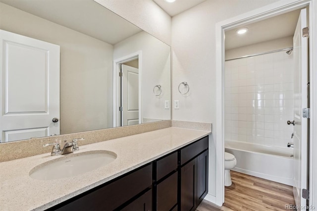 full bath featuring  shower combination, vanity, toilet, and wood finished floors