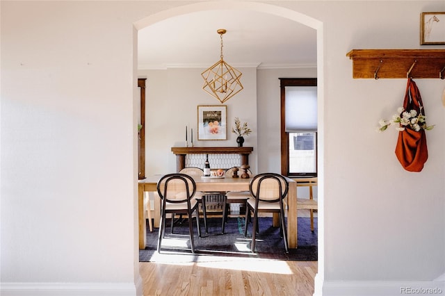 2096 S Logan St, Denver, CO 80210 - dining area featuring arched walkways, wood finished floors, and crown molding