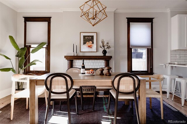 2096 S Logan St, Denver, CO 80210 - dining space featuring wood finished floors, ornamental molding, and a chandelier