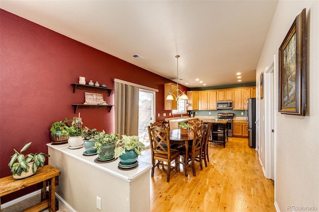 dining space with light wood-type flooring and sink