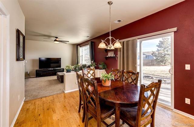 dining area featuring ceiling fan with notable chandelier and light hardwood / wood-style flooring