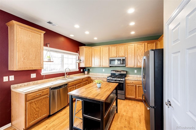 kitchen featuring sink, butcher block counters, stainless steel appliances, and light wood-type flooring