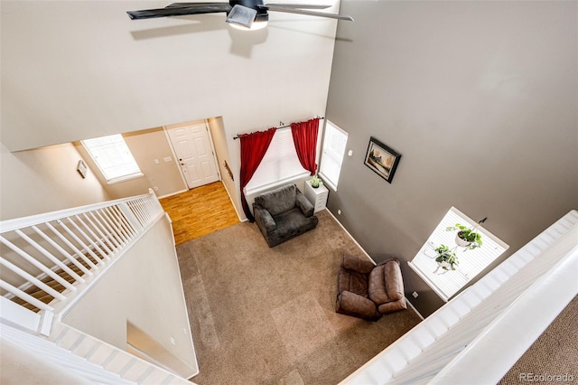 living room with carpet, a towering ceiling, and ceiling fan