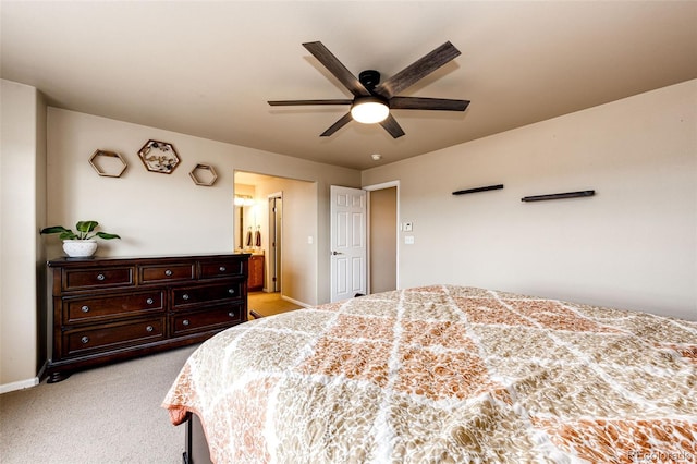 bedroom with light carpet, ensuite bath, and ceiling fan