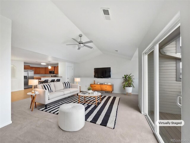 living area featuring ceiling fan, visible vents, light carpet, and vaulted ceiling