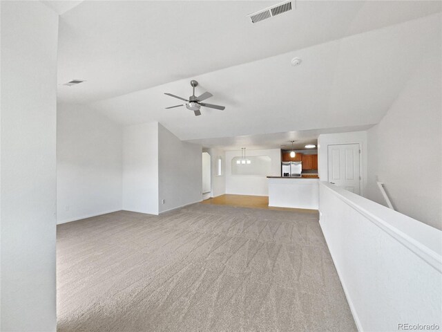 unfurnished living room featuring light colored carpet, ceiling fan, visible vents, and baseboards