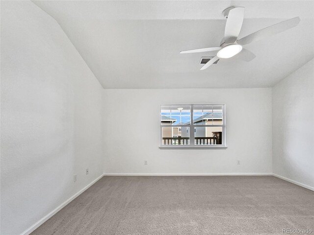 carpeted spare room featuring baseboards, a ceiling fan, and lofted ceiling